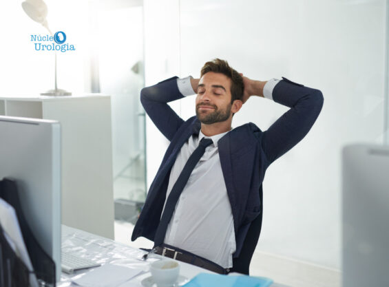 Estresse pode causar cálculos renais. Homem sentado na mesa do escritório com feição relaxada.